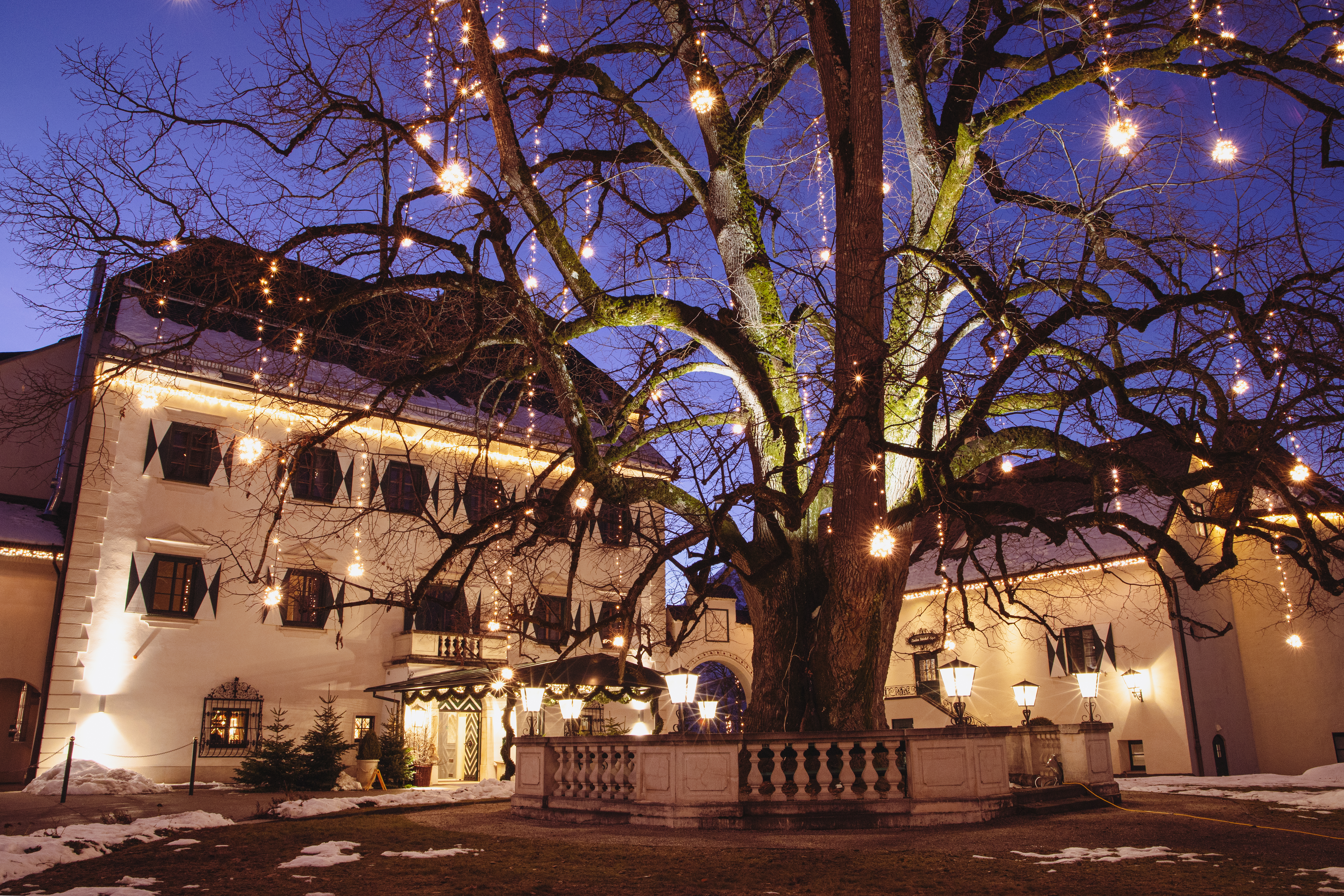 Festliche Hotel Weihnachtsbeleuchtung mit LED-Lichtdesign von MK Illumination – elegante Dekoration für Hotel Weihnachten in winterlicher Berglandschaft.